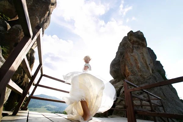 Bride spins between the mountains against the sky — Stock Photo, Image