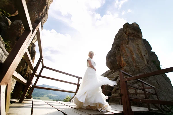 Nevěsta se točí mezi horami proti obloze — Stock fotografie