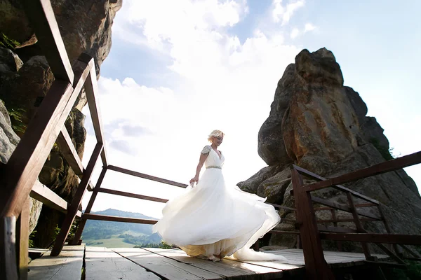 Nevěsta se točí mezi horami proti obloze — Stock fotografie