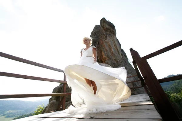 Невеста вращается между горами против неба — стоковое фото