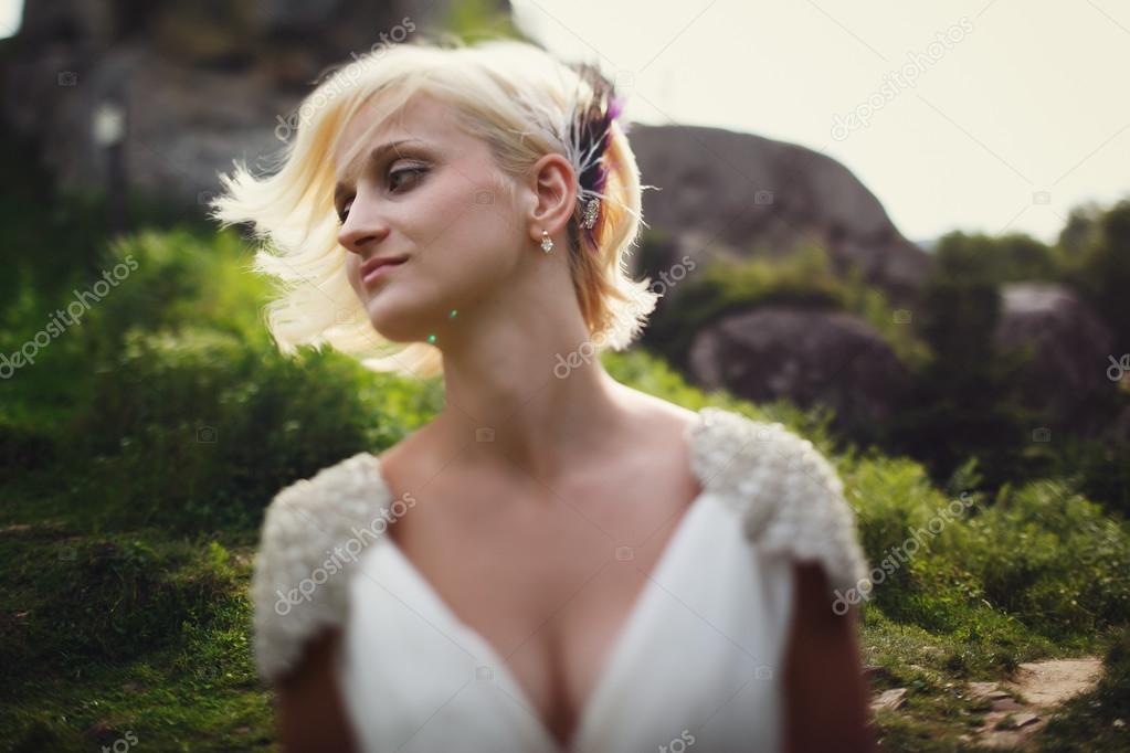 beautiful bride in a wedding dress on a background of mountains 