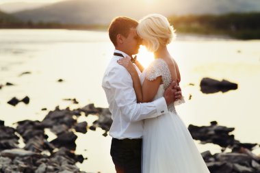 Yeşil çimenlerin üzerinde günbatımında çalışan Düğün çifti