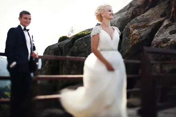 Novia y novio sonriendo en el fondo de las montañas — Foto de Stock