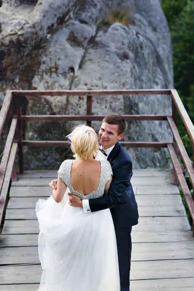 Bröllopsparet på bakgrunden av bro — Stockfoto