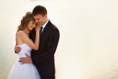 Çift ayakta deniz bir arka plan üzerinde sahilde düğün