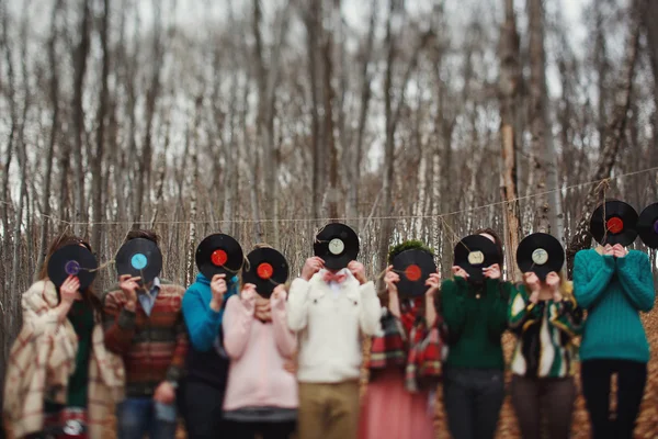 Les gens ferment les plaques de vinyle face dans le bois — Photo