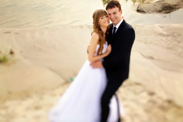 Hermosa novia y novio hermosa sonrisa en el fondo de la arena — Foto de Stock