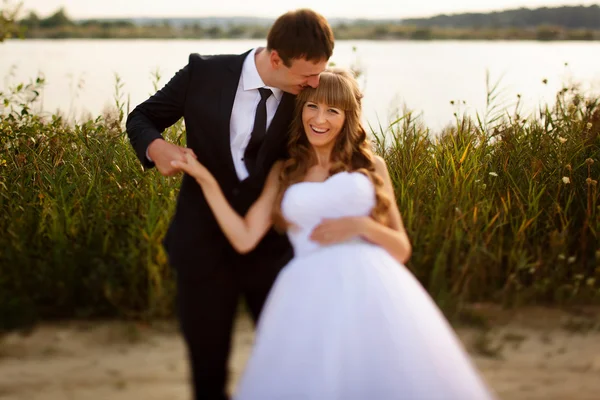 Bruid op een achtergrond bruidegom op het strand — Stockfoto