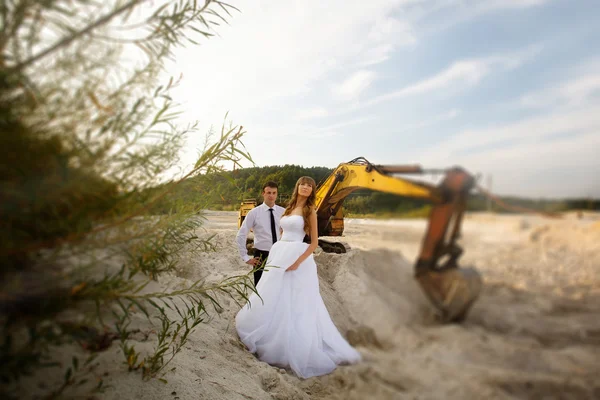 Traktör yakınındaki plajda damat ve gelin portresi eğlenceli — Stok fotoğraf