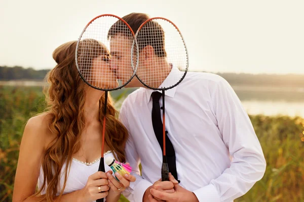 Feliz noivo e noiva jogando tênis em seu dia do casamento — Fotografia de Stock