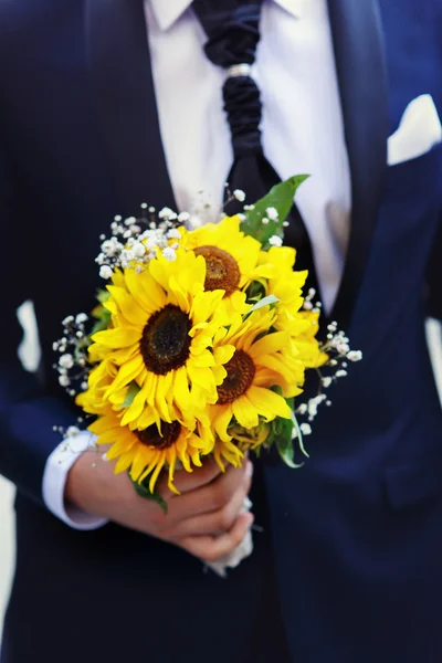 Boeket met zonnebloemen in de handen van de bruidegom — Stockfoto