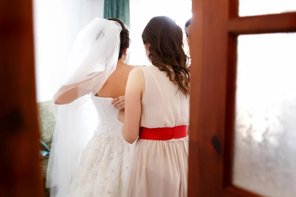 Подружка невесты платье невесты. Фото через двери — стоковое фото