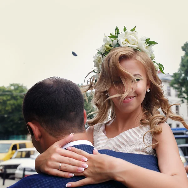 Bonito noivo carregando sua bela noiva rindo em seu — Fotografia de Stock