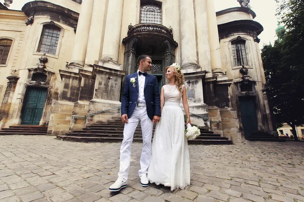 Bride and groom near cathedral — Stock Photo, Image