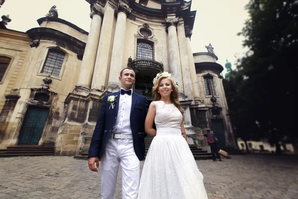 Bride and groom near cathedral — Stock Photo, Image