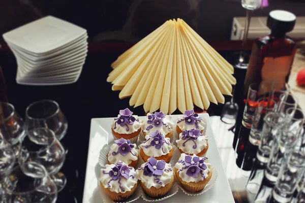 Hermoso pastel de boda y cupcakes en la decoración — Foto de Stock