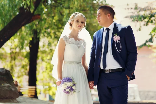 Bruden och brudgummen med en bukett står i parken — Stockfoto