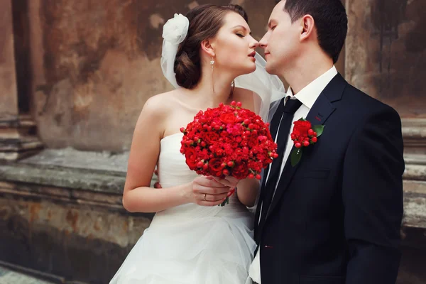 Sensual wedding Couple, groom and bride laughing near the brick — Stock Photo, Image