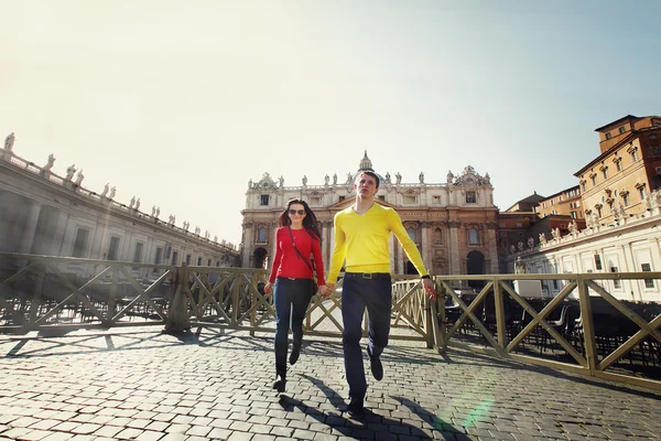 Joven pareja turistas corriendo en el fondo de San Pedro en — Foto de Stock