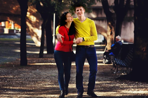 Junges Paar spaziert im Park zwischen Bäumen — Stockfoto