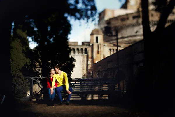 Joven pareja sentada en un banco en el fondo Castillo Sant 'An — Foto de Stock