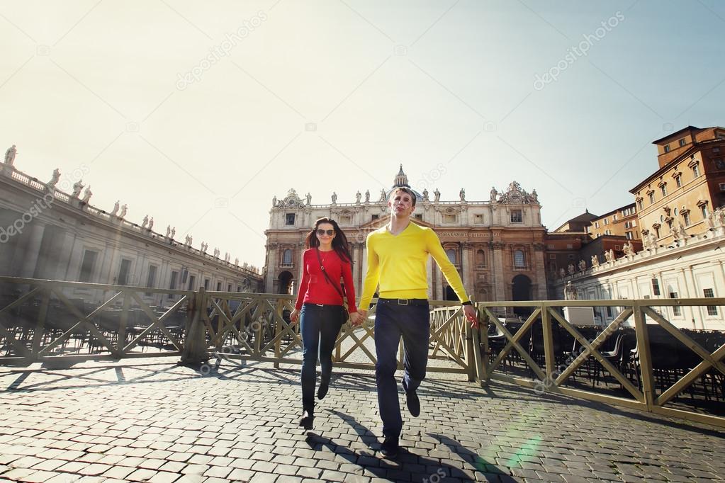 young couple tourists running on the background of St. Peter in 