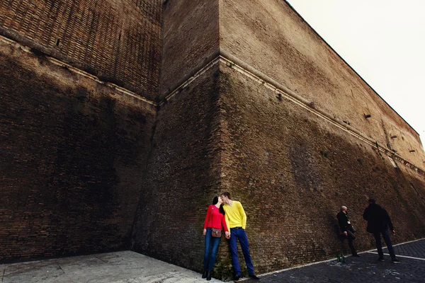 Amantes de la pareja romántica en la pared de ladrillo en Vaticano, Italia. Vacaciones italianas para luna de miel o escapada de fin de semana de jóvenes adultos europeos enamorados en vacaciones de verano . — Foto de Stock