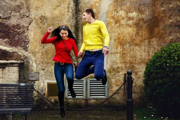 Loving couple running and jumping through the chain — Stock Photo, Image