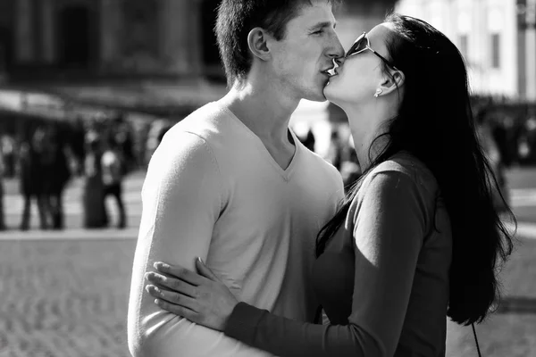 Um par de turistas sorrindo e abraçando na praça central — Fotografia de Stock