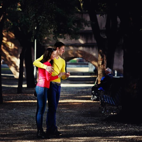 Jovem casal andando no parque entre as árvores — Fotografia de Stock