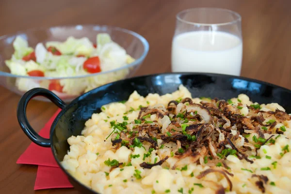 Traditional austrian spaetzle with melted cheese in pan - käsespätzle kasnocken