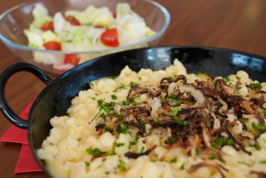 Spaetzle with melted cheese in pan - käsespätzle kasnocken clipart