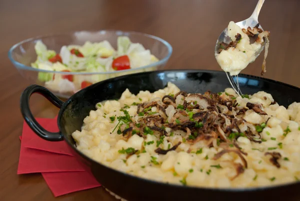 Spaetzle with melted cheese in pan - käsespätzle kasnocken