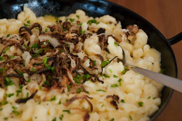 Spaetzle with melted cheese in pan - käsespätzle kasnocken — Stockfoto