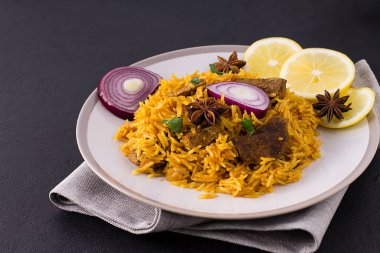 Biryani ve tavuk. Geleneksel Hint yemeği pirinç ve tavuk, baharat ve limonlu. Tabakta..