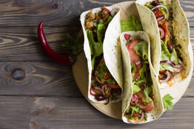 Et ve sebzeli Meksika tacoları. Geleneksel sokak yemekleri. Tahtada..