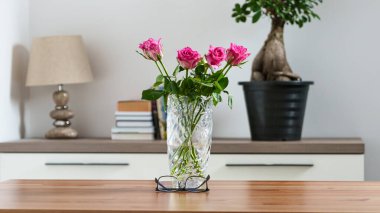 Reçeteli gözlüklerle bir vazo çiçeğin arka planına karşı bir ev ortamında. Yüksek kalite fotoğraf