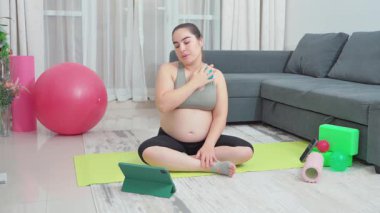 Hamile kadın, leğen kemiği dayanıklılığı, annelik uygunluğu ve esnekliği artırmak için evde esneme ve egzersiz yapıyor. Kızım, oturma odası ve doğum öncesi yoga sirkülasyon, sırt ağrısı ve duruş için. Yüksek kalite 4k görüntü