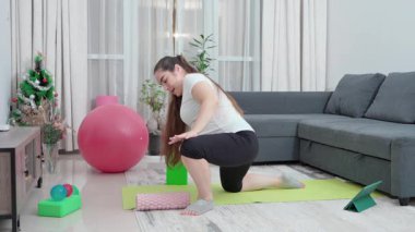 Hamile kadın, leğen kemiği dayanıklılığı, annelik uygunluğu ve esnekliği artırmak için evde esneme ve egzersiz yapıyor. Kızım, oturma odası ve doğum öncesi yoga sirkülasyon, sırt ağrısı ve duruş için. Yüksek kalite 4k görüntü