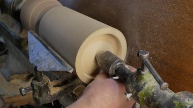carpenter polishes the butt side of the wooden blank