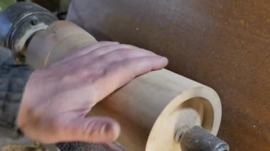 Marangoz eliyle boşluğu dolduruyor. Tahta boş torna torbasında sabitlenir