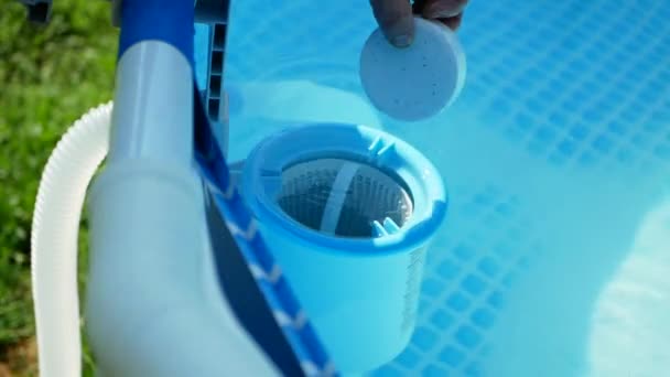 Mano del trabajador pone tabletas blancas en skimmer piscina. Limpieza, desinfección del agua en la piscina. — Vídeos de Stock