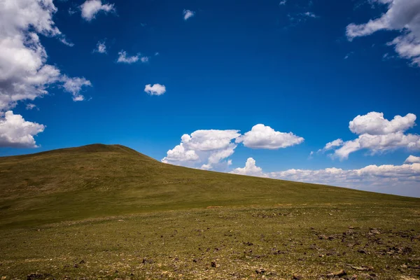 Zielone Wzgórze Górskie Odległym Obszarze Gór Skalistych Przed Błękitnym Niebem — Zdjęcie stockowe
