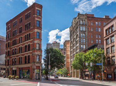 Tarihsel, kırmızı tuğlalı düz binalar Pittsburgh 'da güneşli bir cadde köşesinde canlı mavi gökyüzü var..