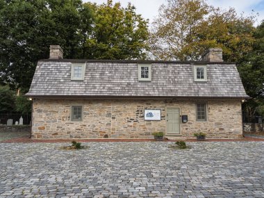 Tarihi Eski İsveç Kilise Müzesi binasının ön manzarasında taş bir ön cephe, ahşap kiremit çatı ve Wilmington, Delaware 'de bir kaldırım taşı avlusu yer alıyor..