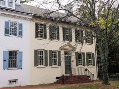 Dover, Delaware 'deki Bradford-Lookerman Evi' nin tarihi evlerinde farklı renkler, kepenkler ve eski bir ağaç sergileniyor..