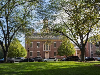 Dover, Delaware 'deki tarihi eski devlet binası, açık ve güneşli bir sonbahar gününde ağaçlarla kaplı bir çimlerin arkasında duruyor..