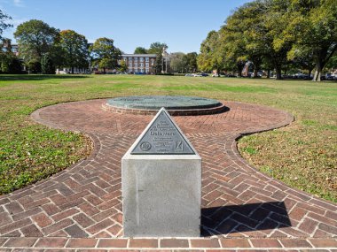 Dover 'daki Yeşil' in arka planında büyük bir bronz pusula ve Yasama Salonu olan tuğla bir geçitte duran Birinci Eyalet Anma Kalemi..