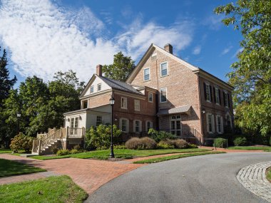 Dover, Delaware 'de bir arka güverte ve tuğla patikalarının bulunduğu Woodburn, Vali Konağı' nın büyük tuğla ve klapa yapısı..