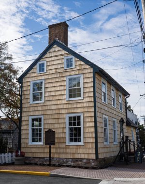 Lewes, Delaware 'deki tarihi Gülle Evi. Geleneksel sedir tozu kaplaması ve parlak bir gökyüzünün altında tuğla baca..